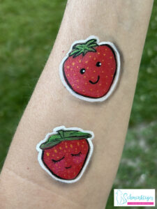 Lustige Erdbeeren im Sticker Style geschminkt auf Arm